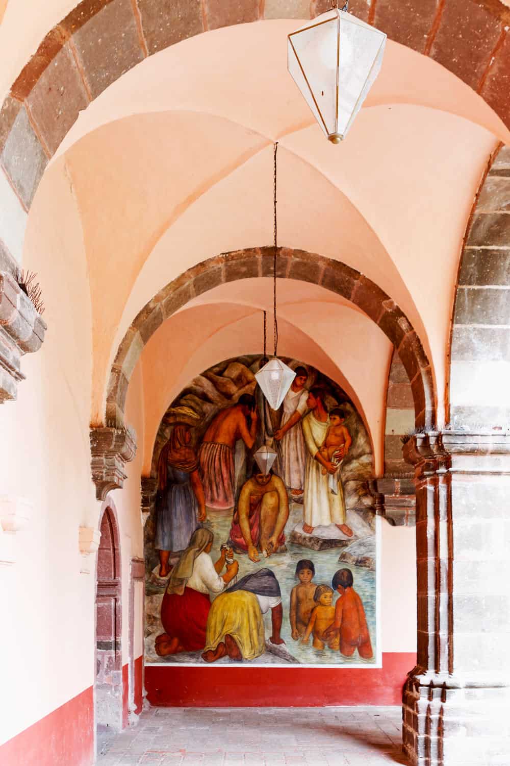 Pink arcade with wall murals in San Miguel de Allende