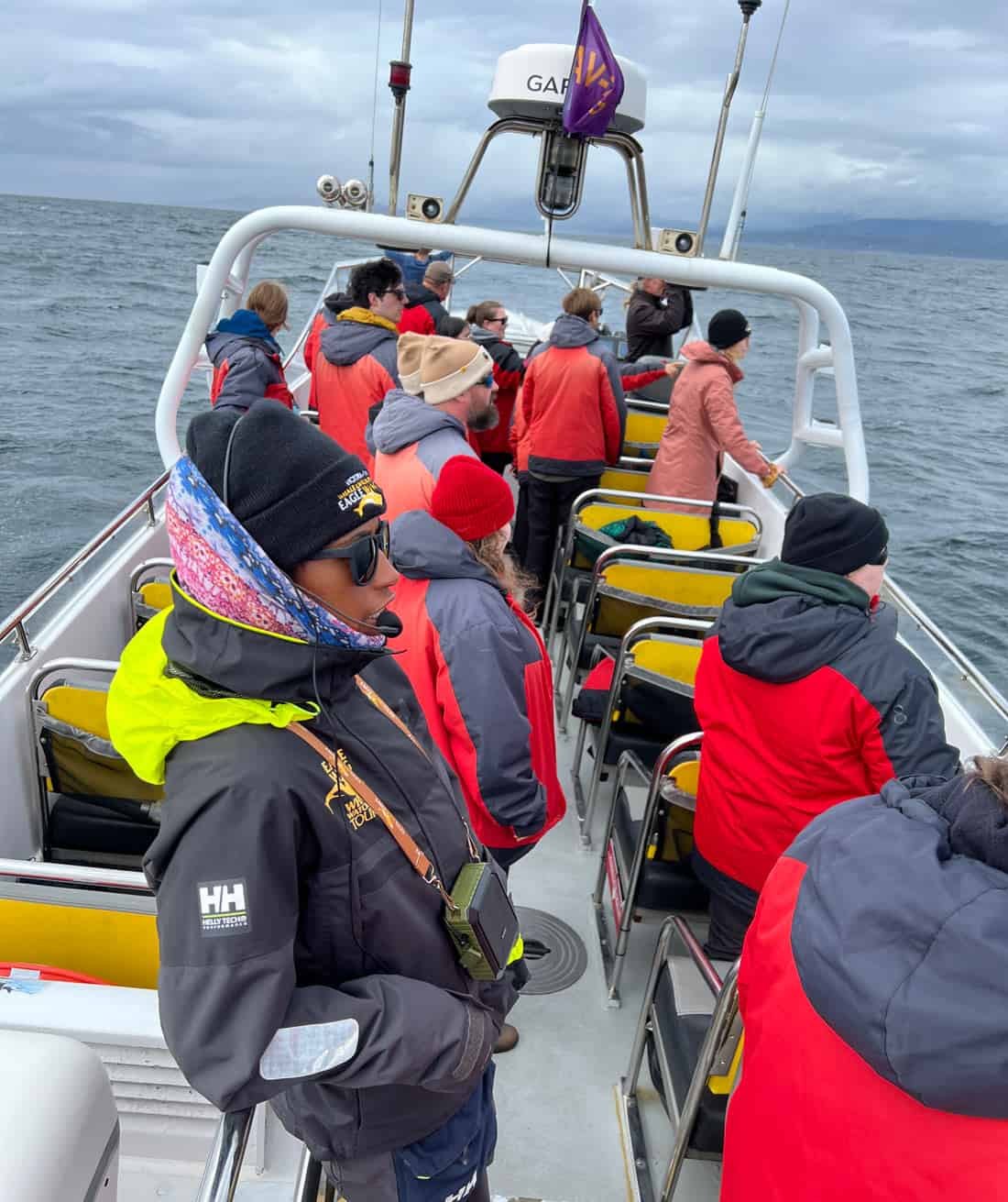 People bundled up in warm clothes on a whale watching speedboat in Victoria, BC