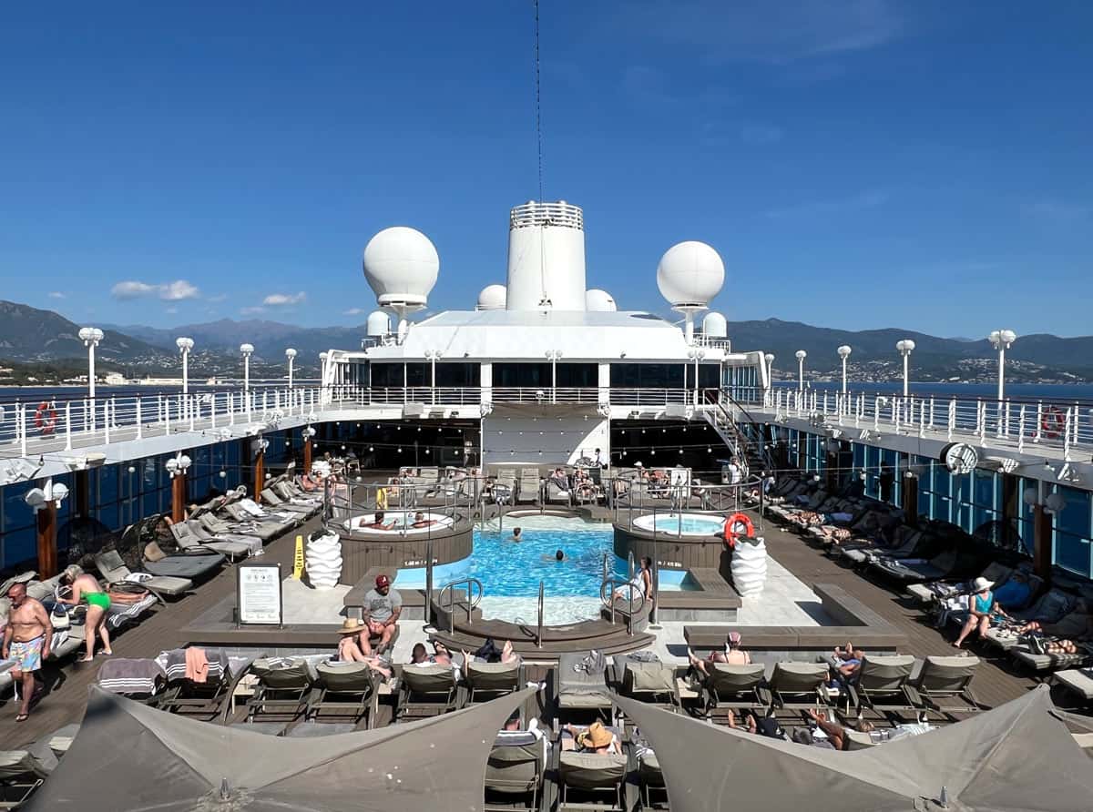 Passengers enjoy sunning and swimming in the pool on the Azamara Quest cruise ship.