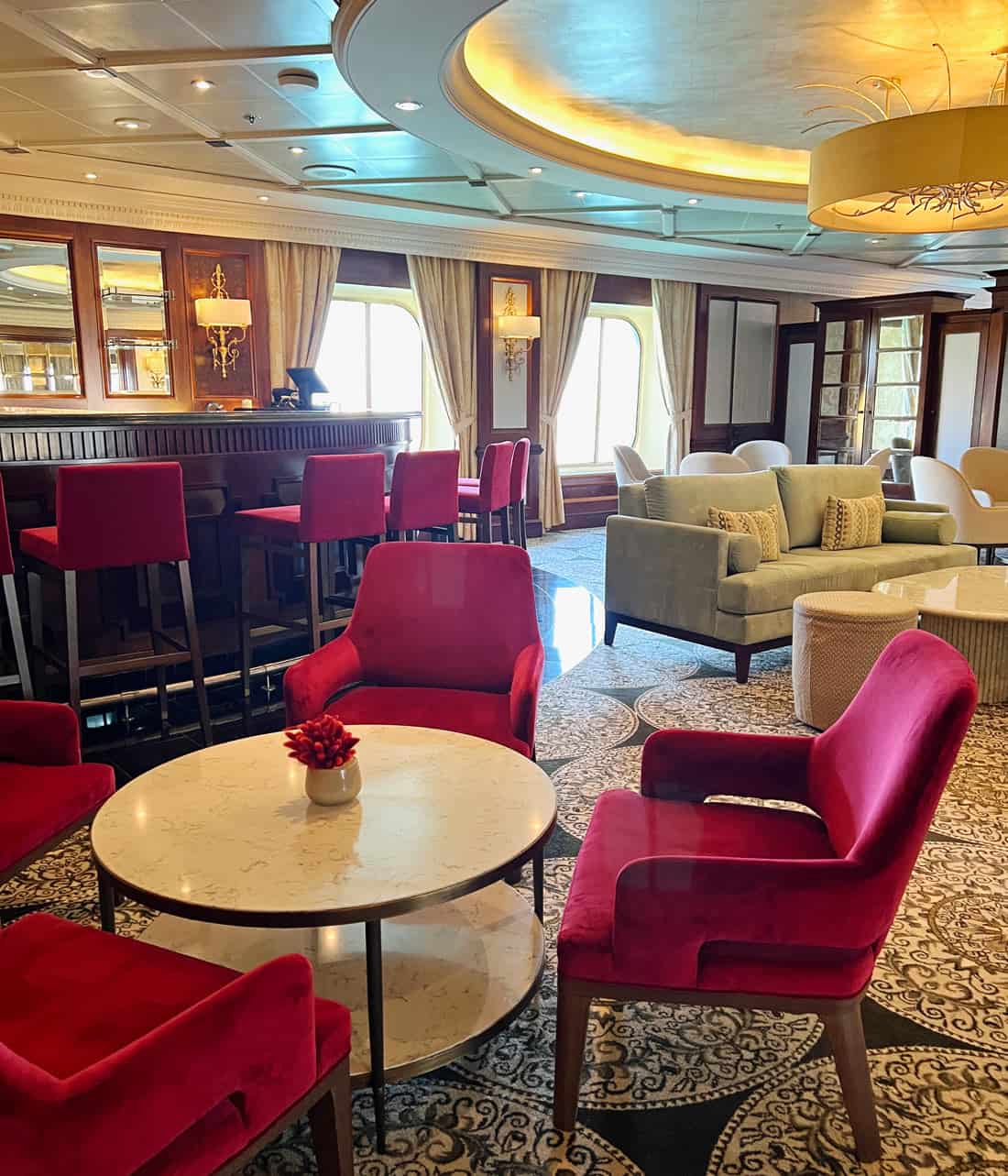 Burgundy chairs and tables in a drinks lounge on Azamara Quest