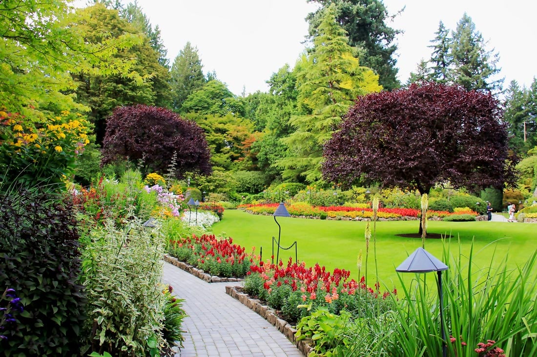 Green lawns and manicured gardens with red and rellow flowers