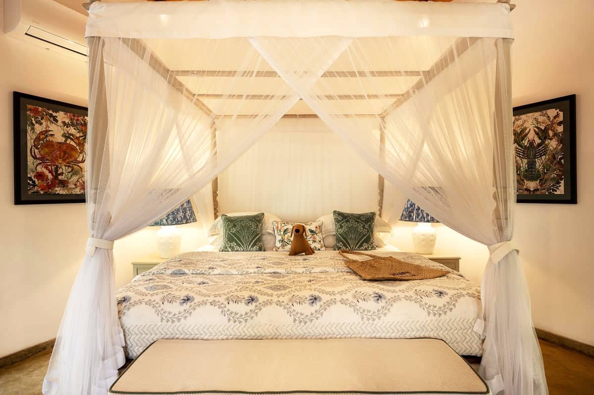 Four-poster bed swathed in white mosquito netting