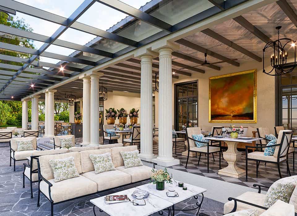 Elegant open-air dining terrace at a new Ella hotel in Sri Lanka, with white columns, white sofas and tables overlooking the gardens